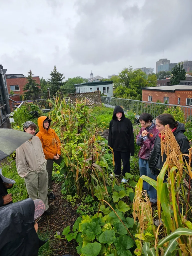 Lil stands with group of community members in garden